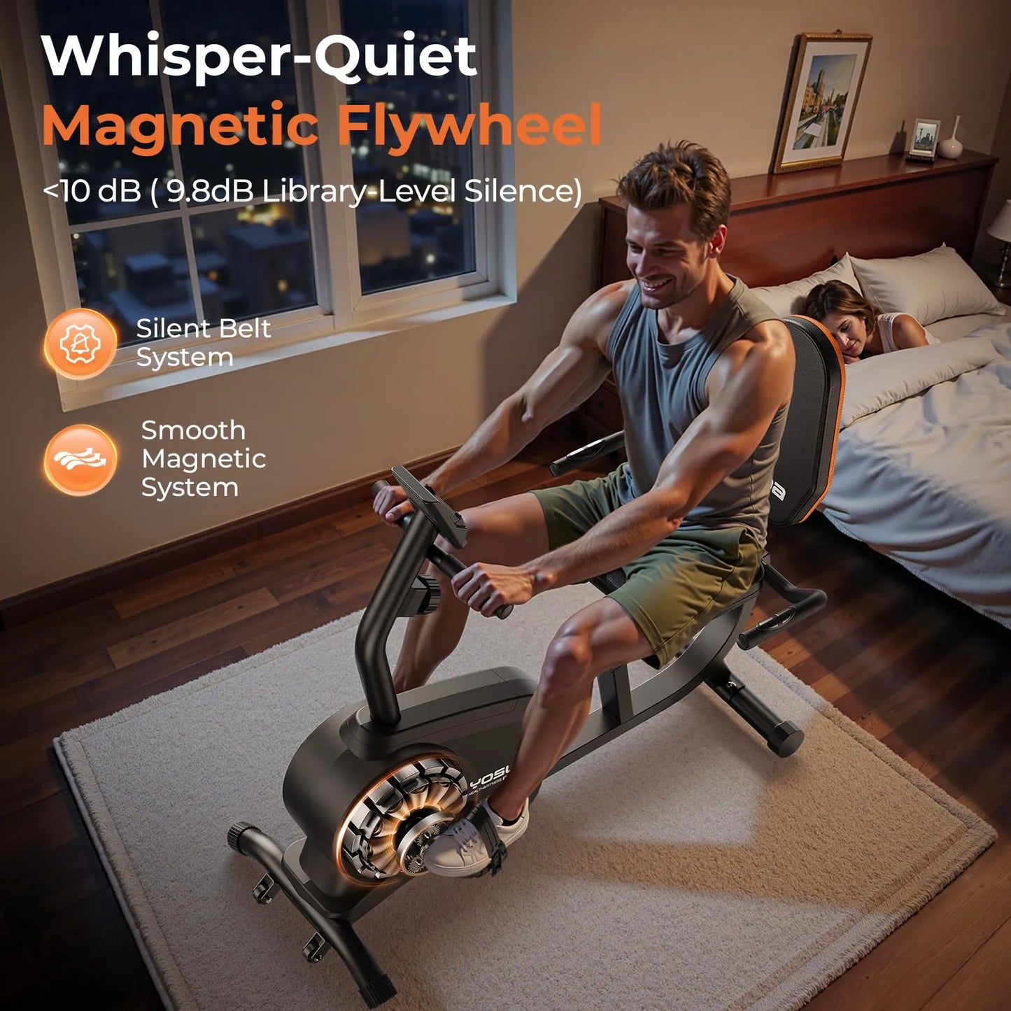 Man exercising on a magnetic flywheel trainer in a bedroom with a child sleeping in the background.