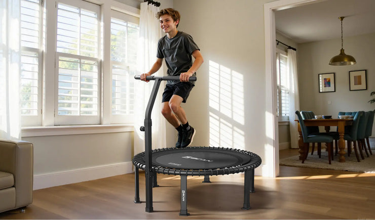A young man is exercising on a mini-trampoline in the living room.