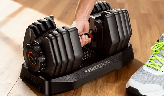 A person is about to pick up adjustable dumbbells from a tray