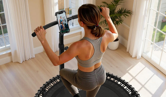 A woman is doing mini-trampoline exercises while following a workout video