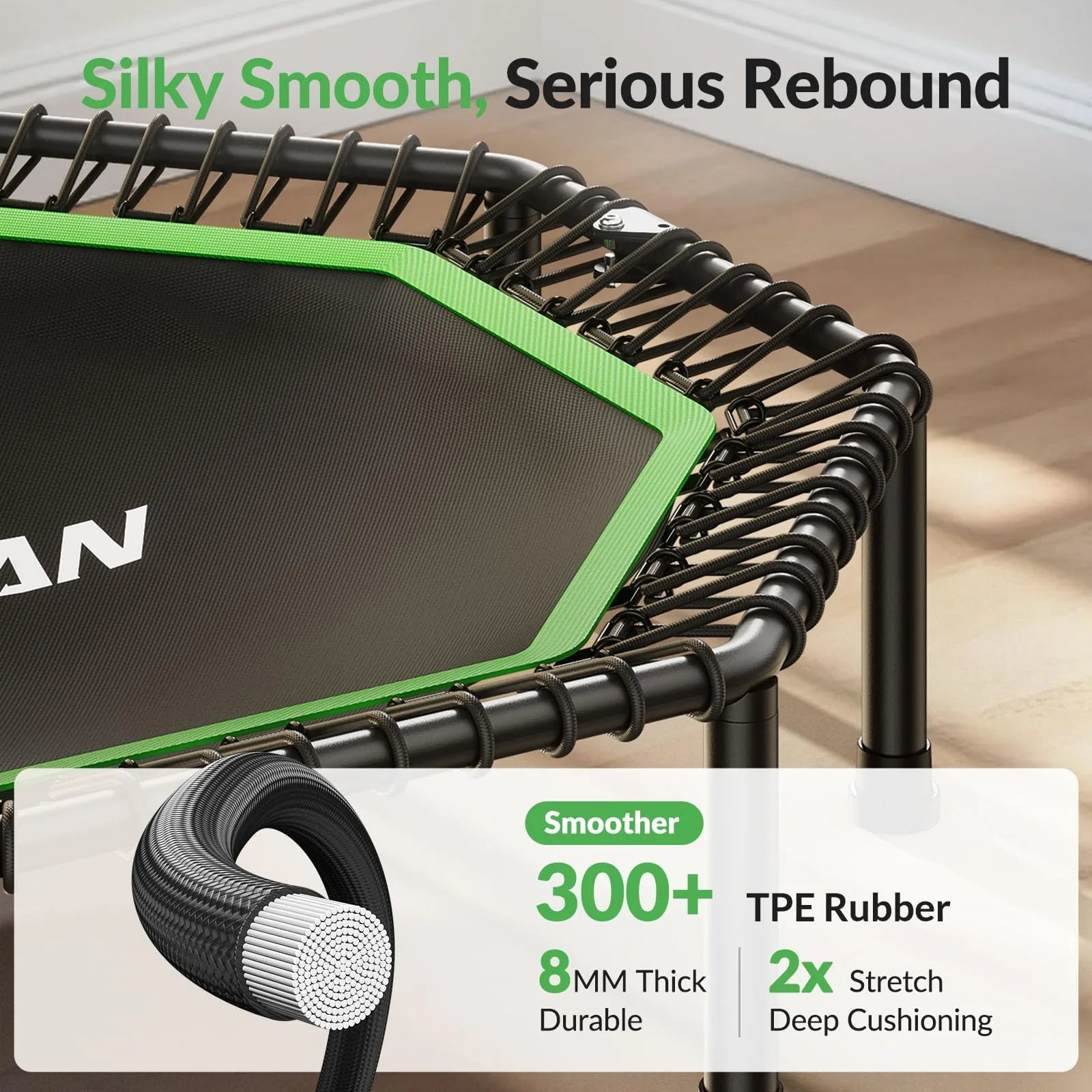 Green and black trampoline with TPE rubber details on a wooden floor.