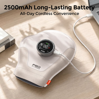 A handheld massage device with a circular digital display and connected white charging cable, resting on a light wood desk. The product is branded 'FED MYSTERY' in black text on the front.