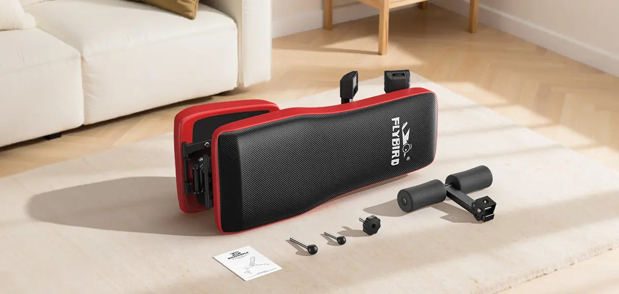 Black and red exercise bench with components on a light-colored floor.