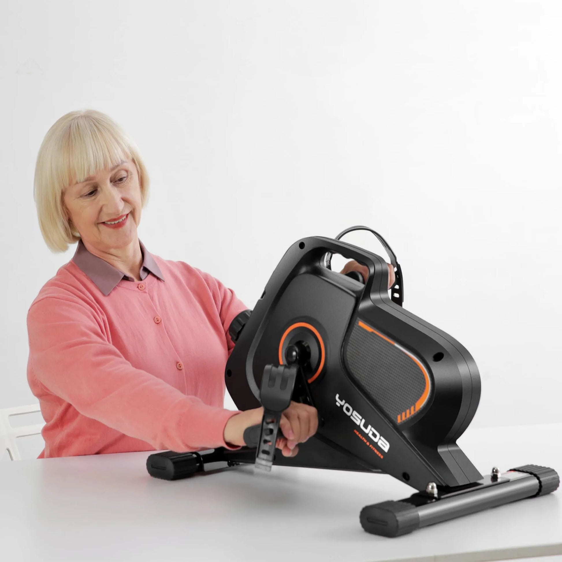 Woman using a Yosuda exercise bike on a white background